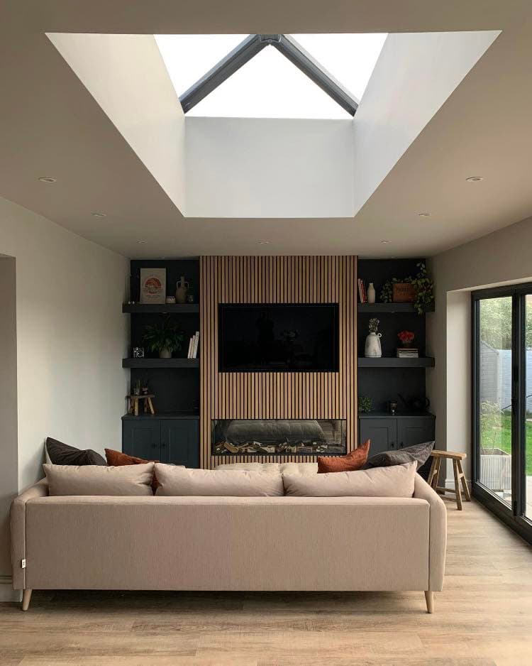 Home improvement — living room with skylight and feature media wall